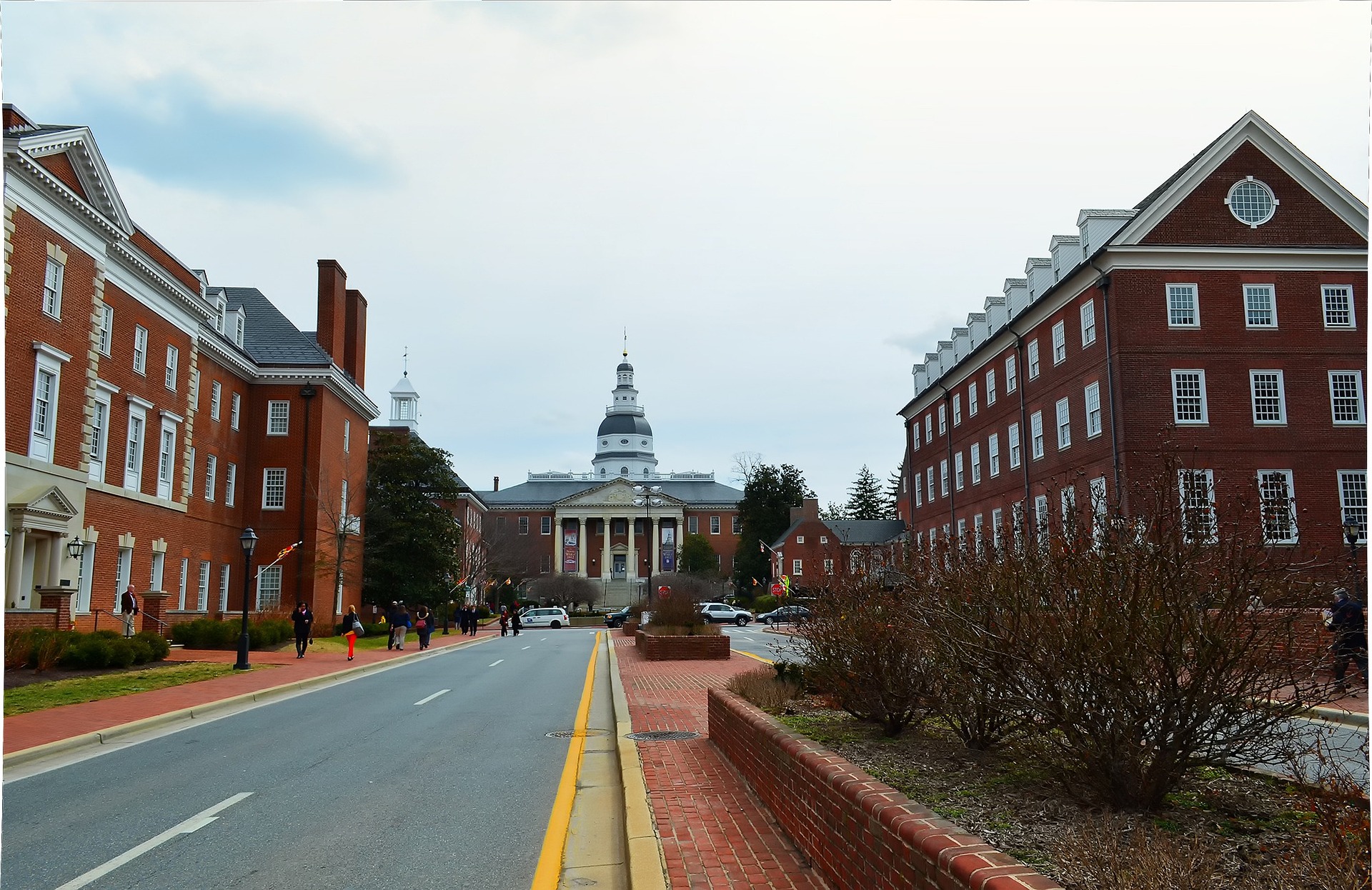 A street in Annapolis Maryland with brick office buildings to the left and right, and Maryland's State Capitol building at the end of the road.