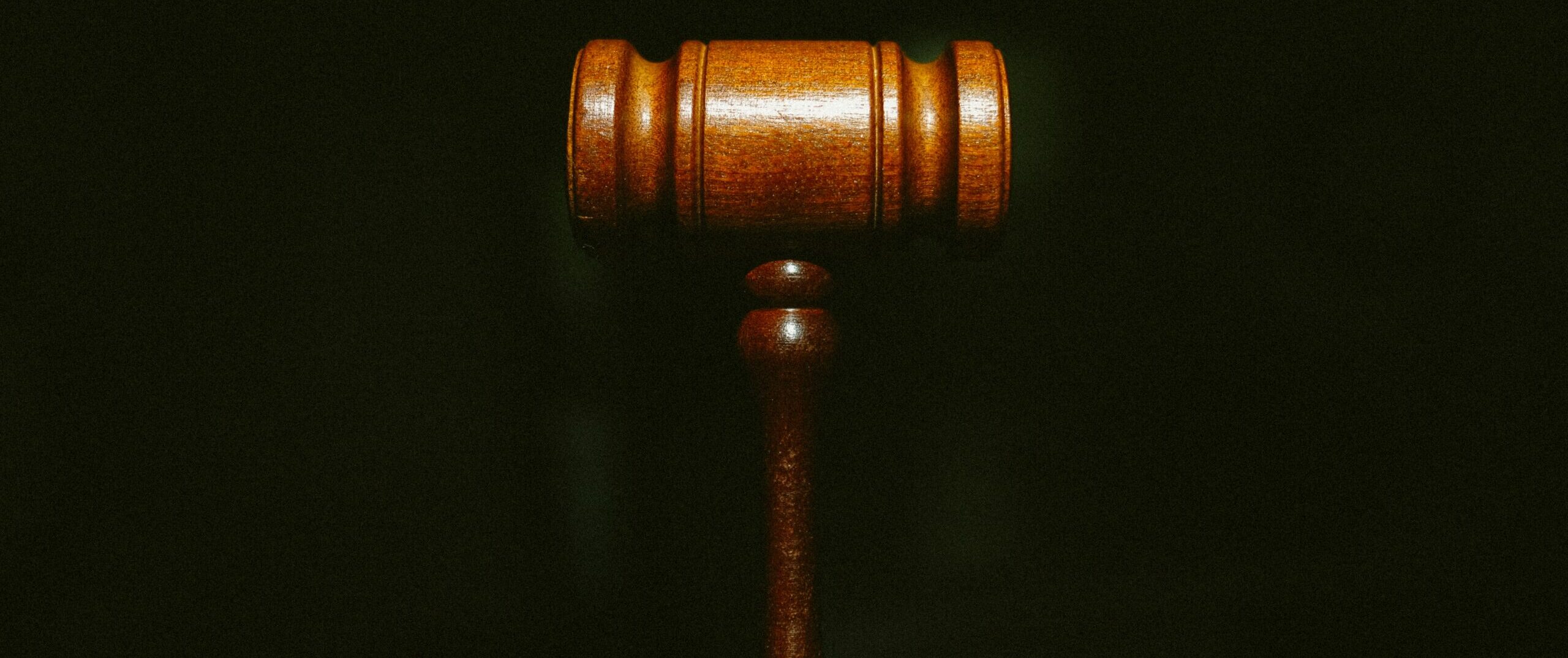 A wooden gavel on a black background.