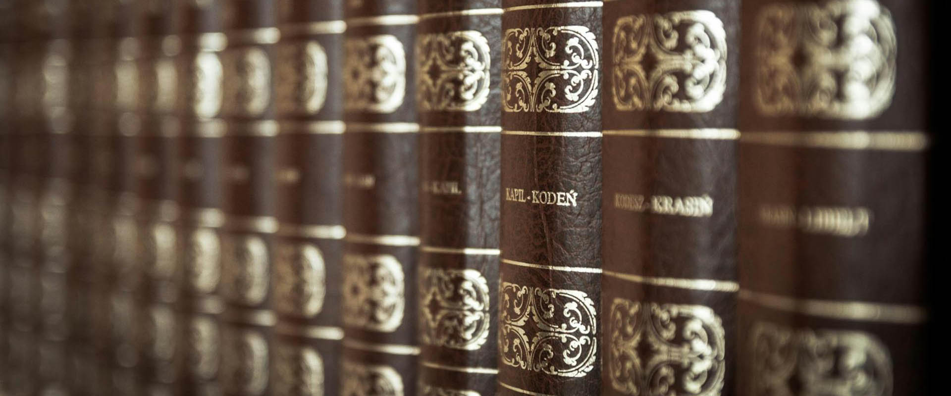 A library of brown leather bound books.