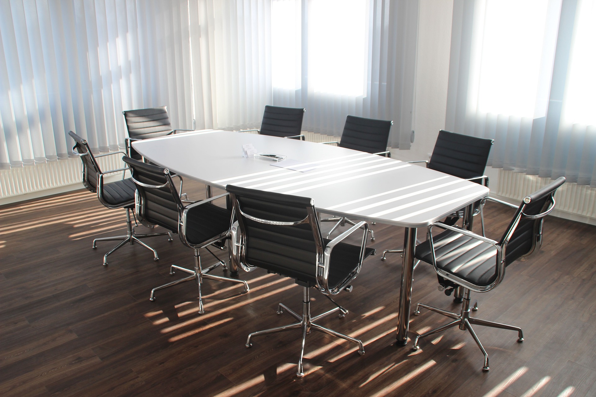 An modern boardroom table in a well-lit office space.